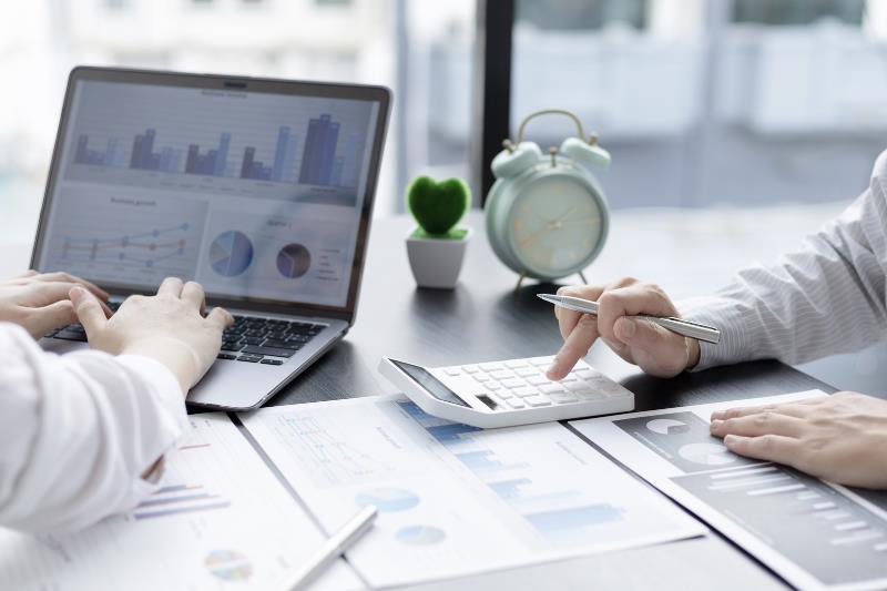 Professionals analyzing financial data with graphs, charts, and calculator – DAFZA Approved Auditors in Dubai