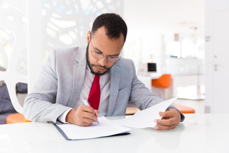 Businessman reviewing documents at a desk – JAFZA approved auditors in Dubai